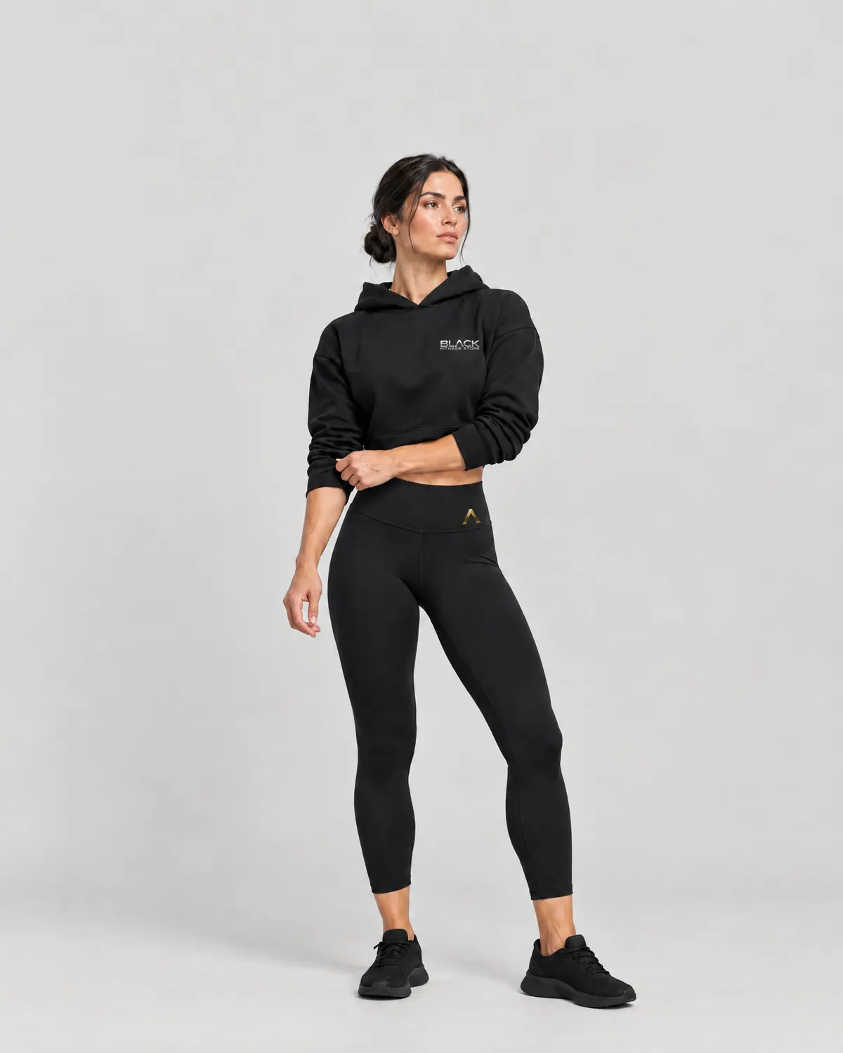 Atleta con buzo corto negro con el logo de Black Fitness Store y calza negra de tiro alto